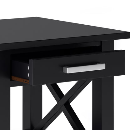 A close-up of the Kitchener - Handcrafted Table, a black wooden desk with an open drawer featuring a silver handle and crossed support beams beneath the tabletop.