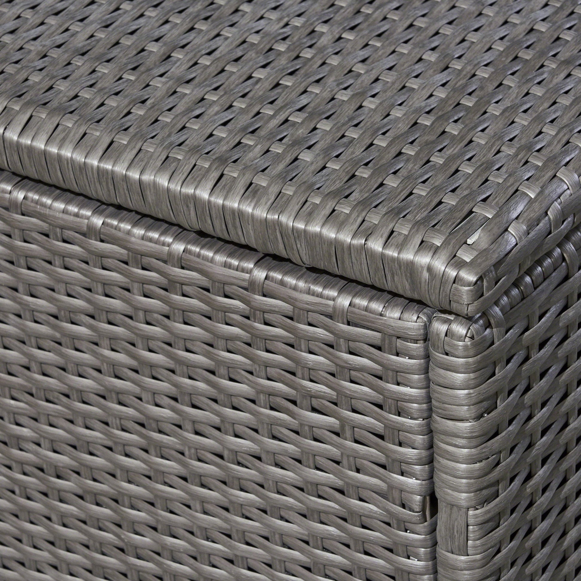 Close-up of the corner of the Santa Rosa - Storage Table, highlighting its gray woven rattan design with detailed interlaced pattern and smooth, rounded edges.