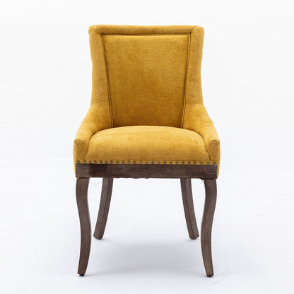 A set of two Ultra Side Dining Chairs with thickened fabric in mustard yellow, neutrally toned solid wood legs, and bronze nail head trim along the bottom edge, shown against a plain white background.