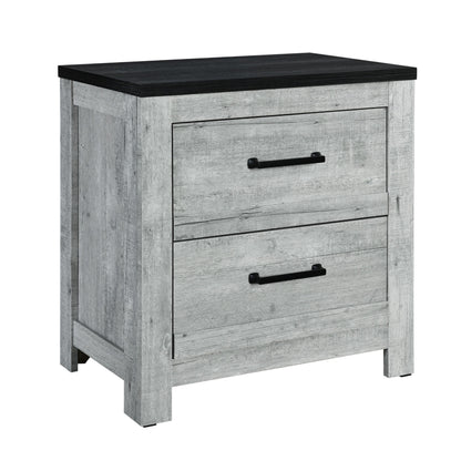 The Couch.com Kicks Nightstand features two drawers, a durable wood construction with a gray wash finish, black metal handles, and a contrasting dark top. Shown against a white background, it offers modern style and weather-resistant design.