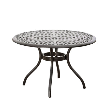 The Tranquilius outdoor round dining table features a black metal lattice tabletop, an umbrella hole, and four curved legs, shown on a white background.