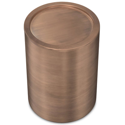 The Corbin Handcrafted Metal Side Table is a cylindrical piece with a smooth, brushed copper finish and a flat, round top.