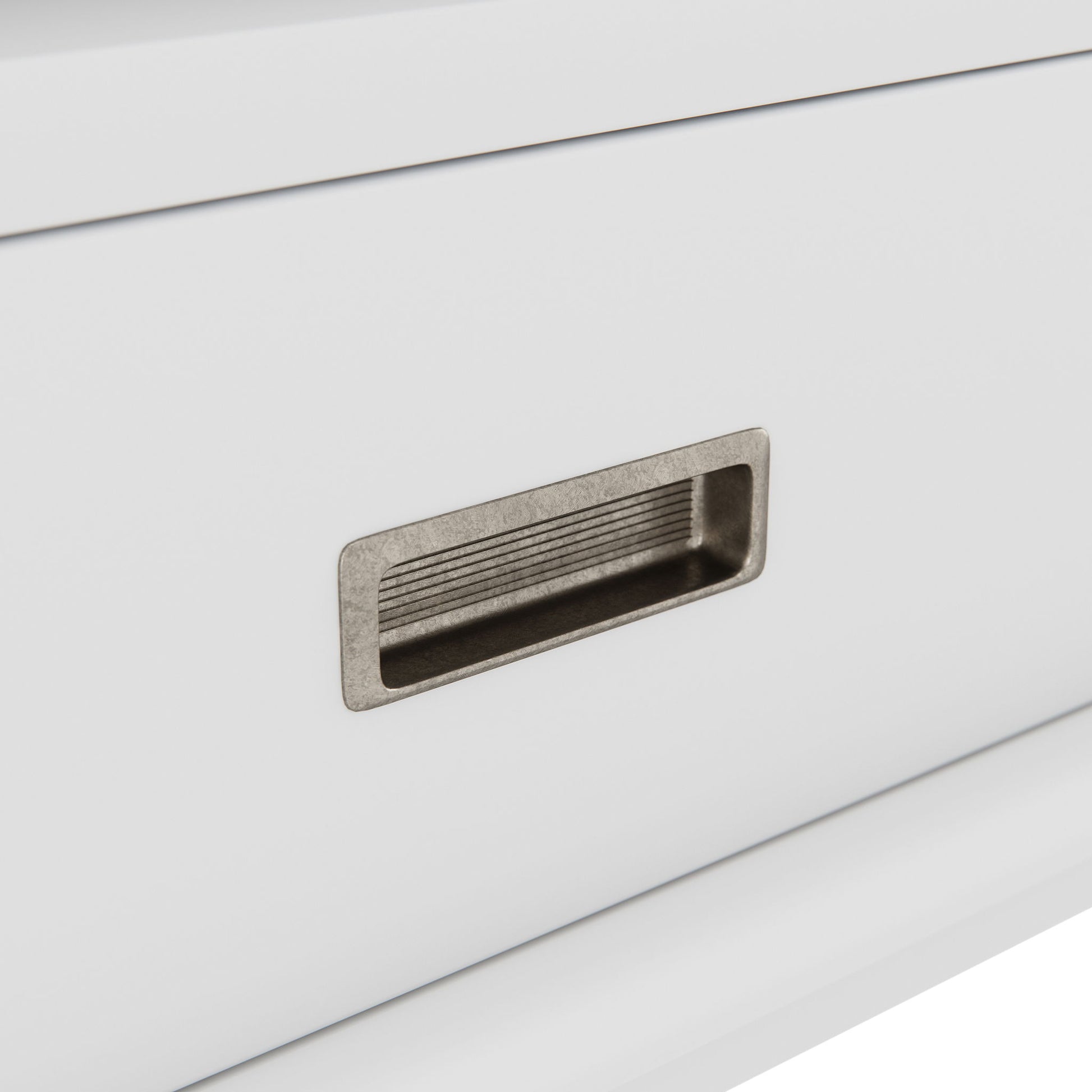Close-up of a white drawer on the Draper - Mid Century Wide Bookcase And Storage Unit, featuring a rectangular, recessed metal pull with horizontal grooves inside the handle.