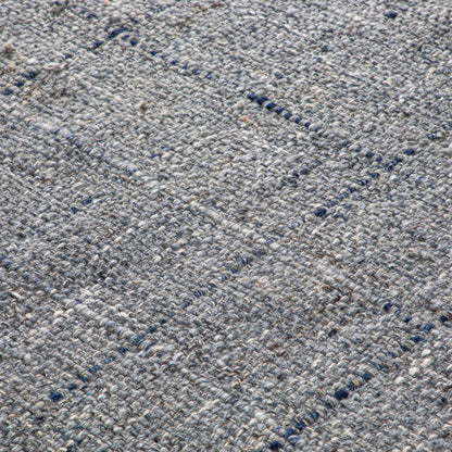 Close-up of the Tenney Handcrafted Area Rug, featuring textured woven gray fabric with a subtle grid pattern and visible yarn threads.