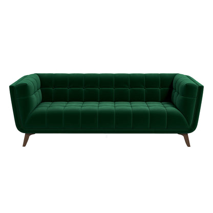The Addison sofa features a mid-century modern design with dark green velvet upholstery, deep tufted cushions, angled arms, and wooden legs, shown against a white background.