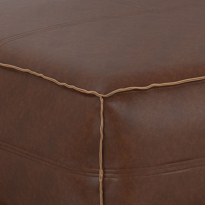 Close-up of the Brody Large Square Coffee Table Pouf corner, highlighting its brown leather finish with detailed stitching and contrasting thread along the seams.
