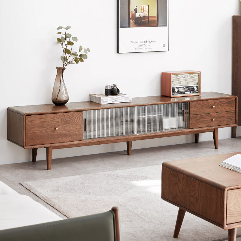 A TV Cabinet with Chinese Changhong glass doors and two drawer storage stands on tapered legs in a minimalist living room, topped with a vase of greenery, books, and a vintage radio.