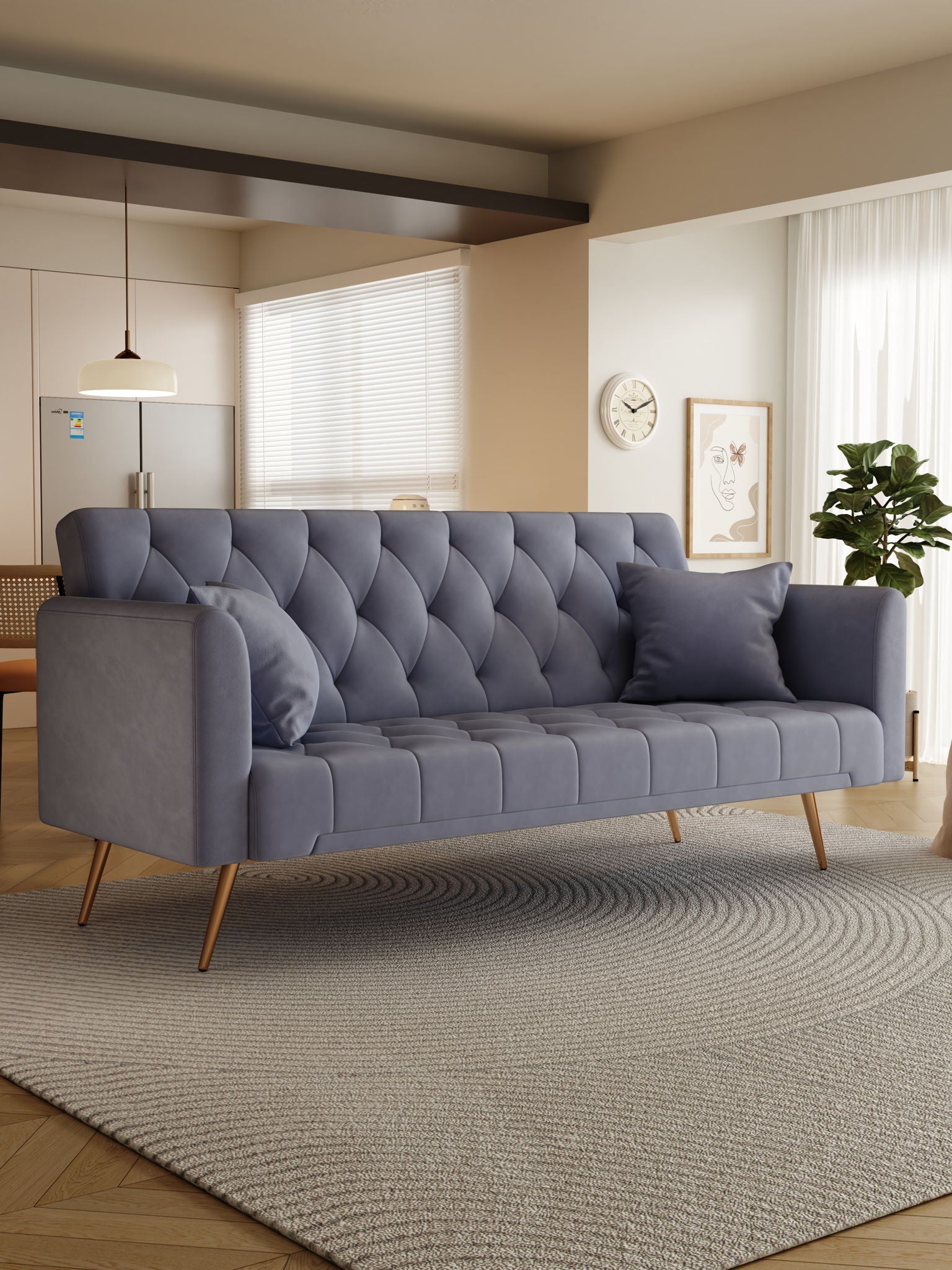 A modern living room features the Convertible Double Folding Living Room Sofa Bed in gray with two matching pillows, wooden legs, a round textured rug, potted plant, wall art, clock, and a kitchen area bathed in natural light.