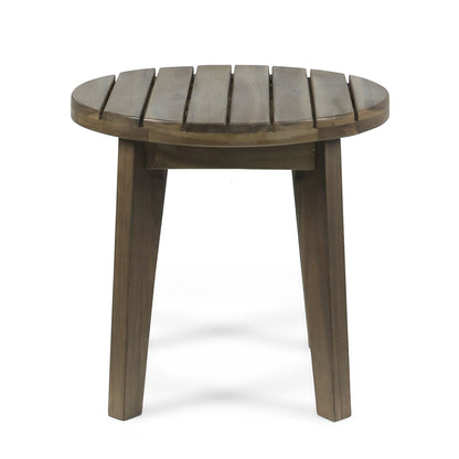 The Outdoor Acacia Wood Side Table features a small, round slatted top and three angled legs for stability, crafted from weather-resistant wood and displayed against a white background.