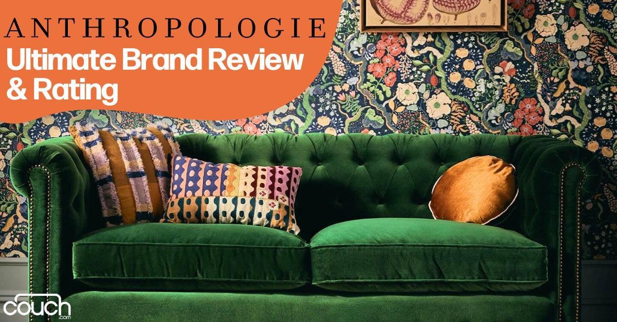 A green velvet sofa with colorful cushions is placed against a floral wallpaper backdrop. Text at the top reads, "Anthropologie Ultimate Brand Review & Rating," and the couch.com logo is visible in the corner.