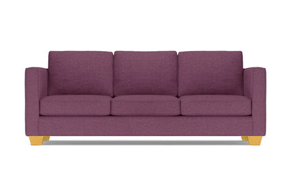 The Catalina Sofa, with its modern design in a purple hue, comes complete with three cushions. It features straight arms and light wooden legs, all showcased against a white background.