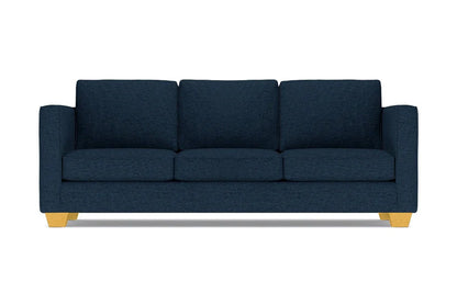 The Catalina Sofa is a dark blue three-seater featuring square cushions and light wooden legs, set against a white background.
