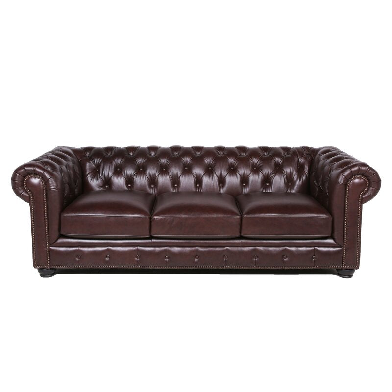 Introducing the Birch Lane Freddie 95'' Leather Sofa—a dark brown Chesterfield design with tufted back and arms, complete with three seat cushions and nailhead trim on the front.