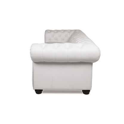 Side view of a white Birch Lane Freddie 95'' Leather Sofa on black legs. The back and armrests feature deep button detailing, giving it a classic, luxurious look. The sofa is set against a plain white background.