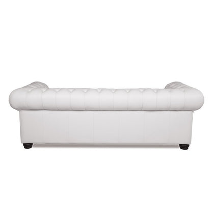 Back view of the Birch Lane Freddie 95'' Leather Sofa in white, featuring tufted detailing and rounded armrests, set on dark wooden legs.