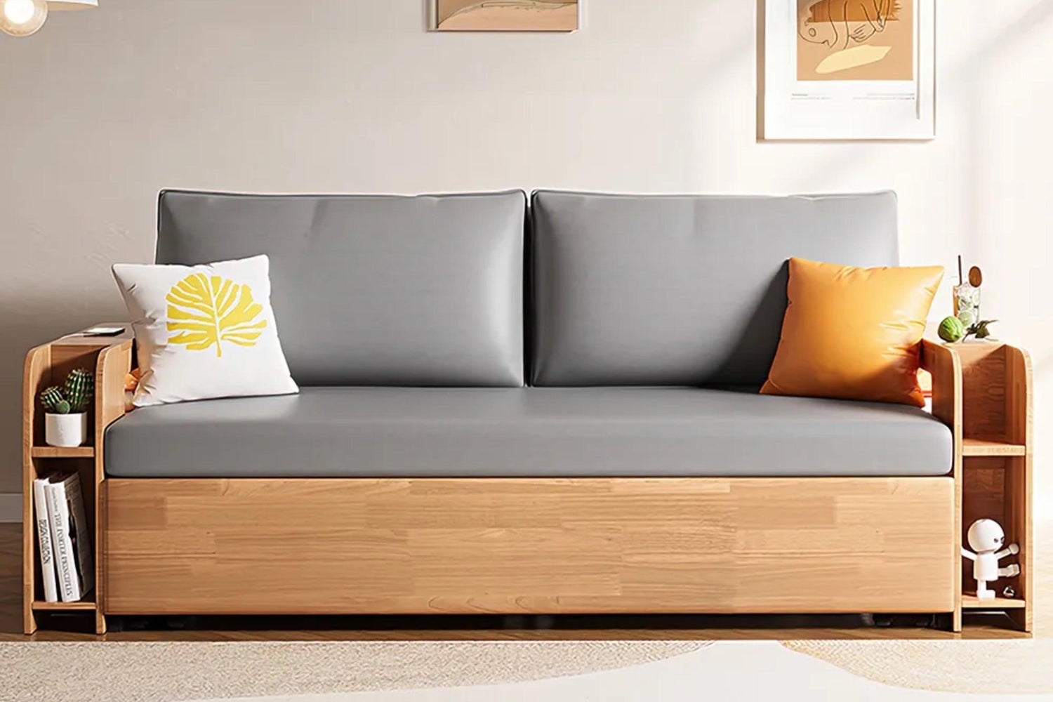 Modern sofa with light gray cushions and wooden frame, featuring side storage shelves. A white pillow with a yellow leaf design and an orange pillow are on the sofa. Neutral wall background with framed art. Small plants are positioned on the side shelves.