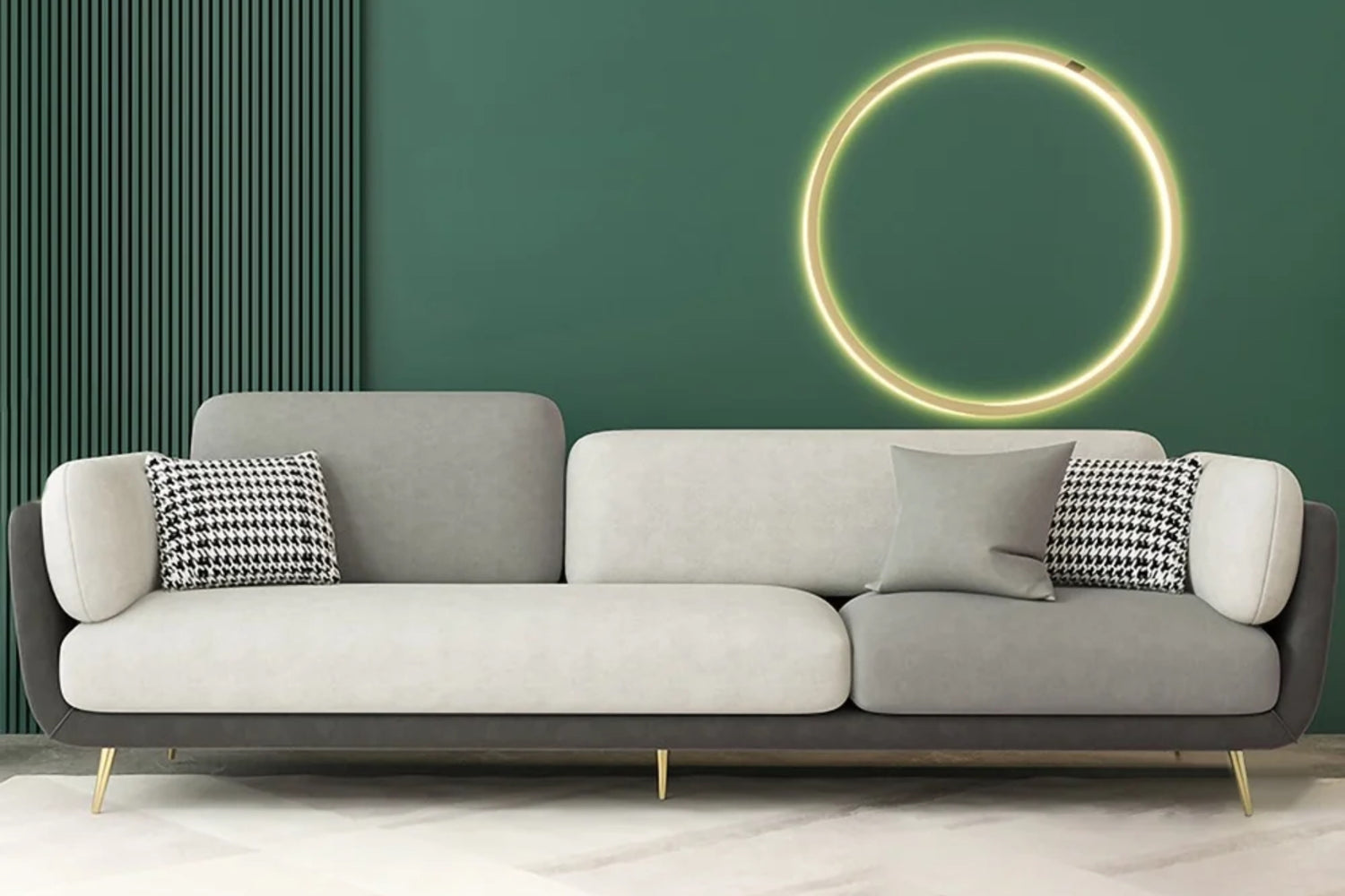 A modern living room features a sleek gray sofa with a black and white houndstooth pillow and a plain gray pillow. A green accent wall is adorned with a circular, illuminated light fixture, and the floor displays a subtle geometric pattern.