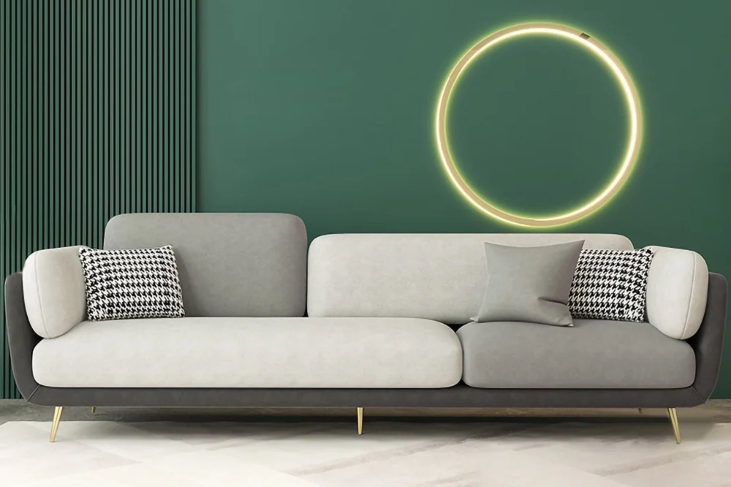 A modern living room features a sleek gray sofa with a black and white houndstooth pillow and a plain gray pillow. A green accent wall is adorned with a circular, illuminated light fixture, and the floor displays a subtle geometric pattern.