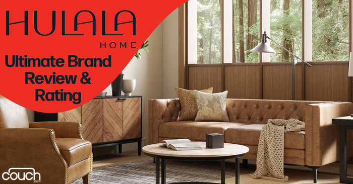 Modern living room with a brown leather sofa, accent pillows, a floor lamp, a wooden coffee table, and a sideboard. Large windows offer a view of green trees. Overlaid text reads: "HULALA HOME Ultimate Brand Review & Rating." Logo: "Couch.com.
