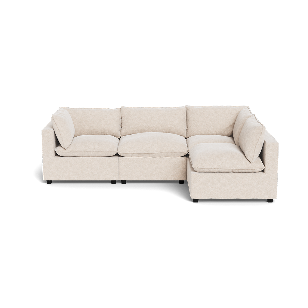 The Kova Pillow Cushion L-Shape sectional, featuring plush cushions and armrests in beige, is displayed against a white background.