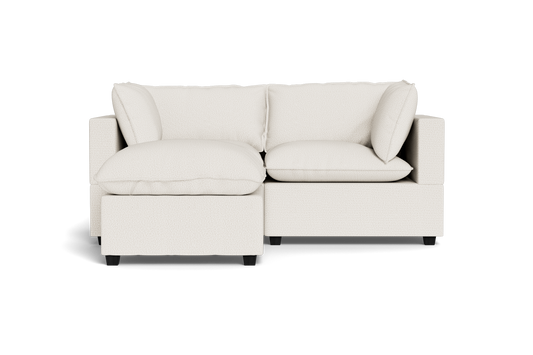 The Kova Pillow Cushion Sofa 86" with Ottoman features a modern design in light beige with plush cushions, showcased against a plain black background.