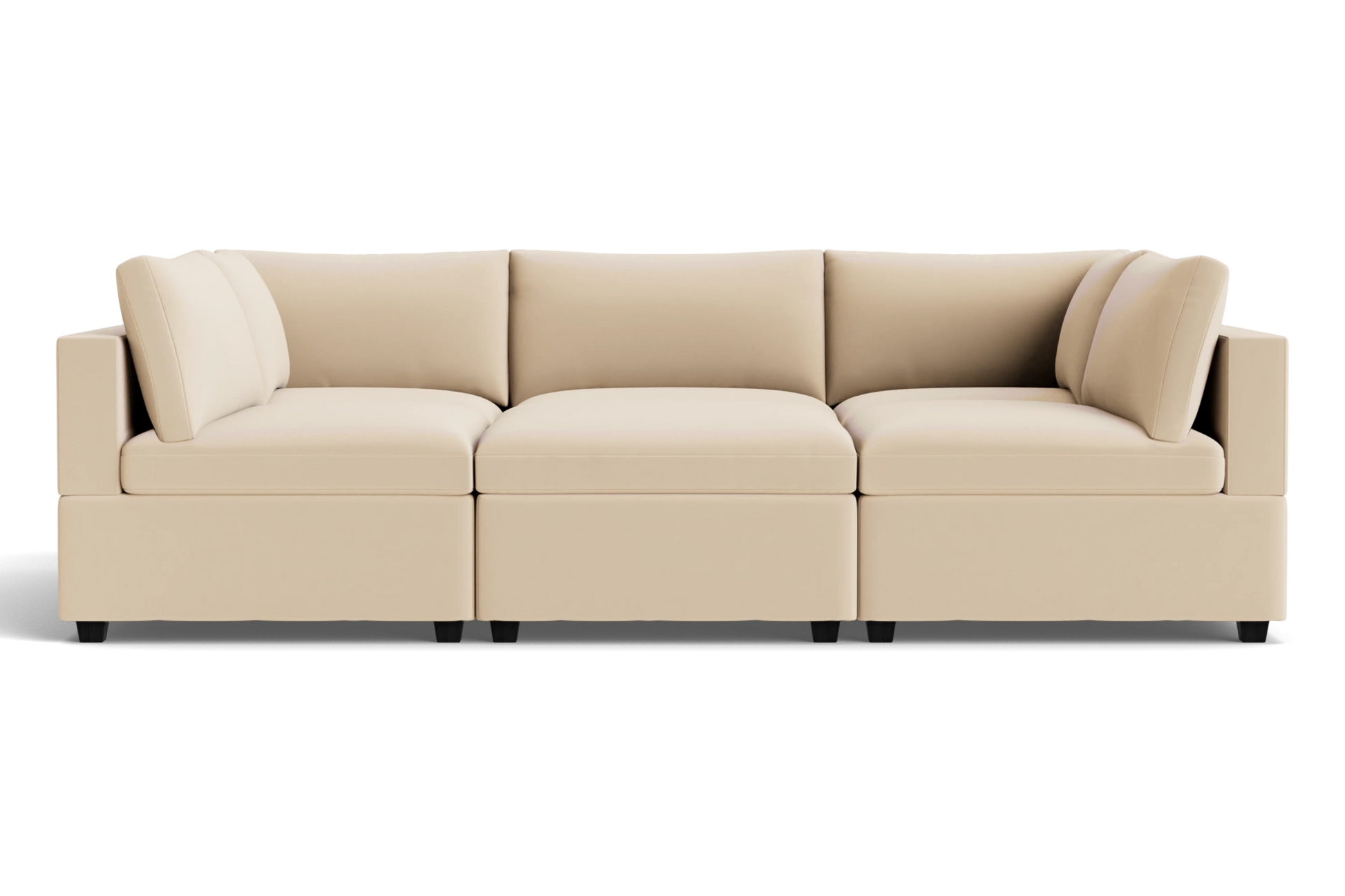 The Kova Box Cushion Pit is a modern beige sectional sofa with three seat cushions, six back cushions, and square arms, set against a plain black background.