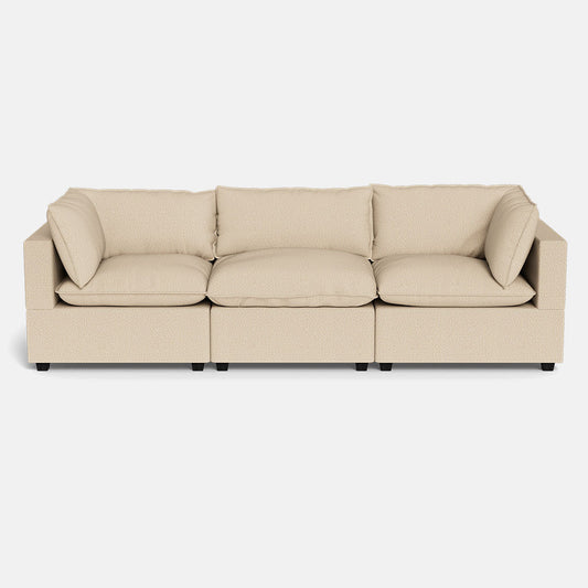 The Kova Pillow Cushion Sofa 122" is a beige, three-seater modular sofa with plush cushions and wide armrests, shown from the front against a plain white background.