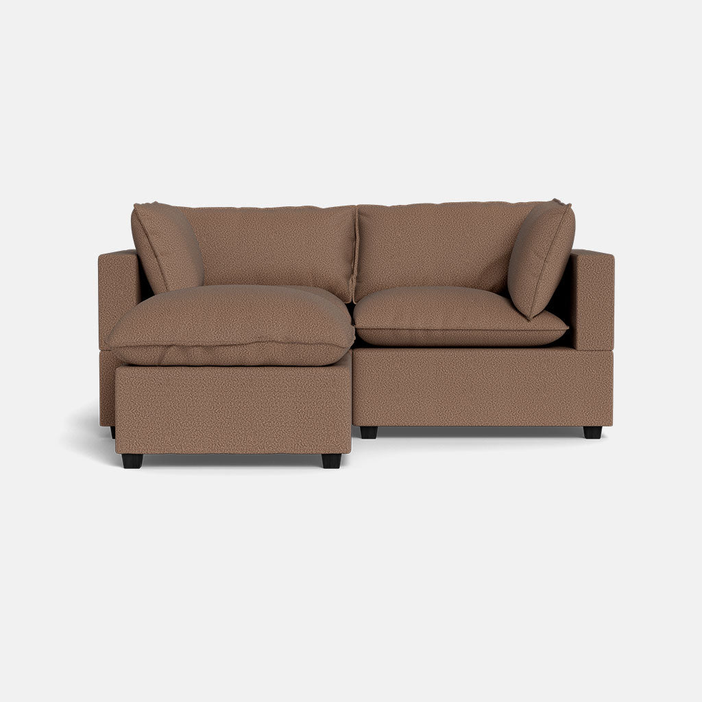 The Kova Pillow Cushion Sofa 86" + Ottoman is a modern brown sectional with plush cushions and a left-side chaise, shown on a plain white background.