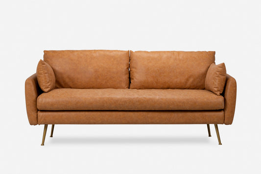 The Park Sofa is a modern tan leather sofa featuring two seat and back cushions, two matching side pillows, slim arms, and four slender gold-colored metal legs, shown against a plain white background.