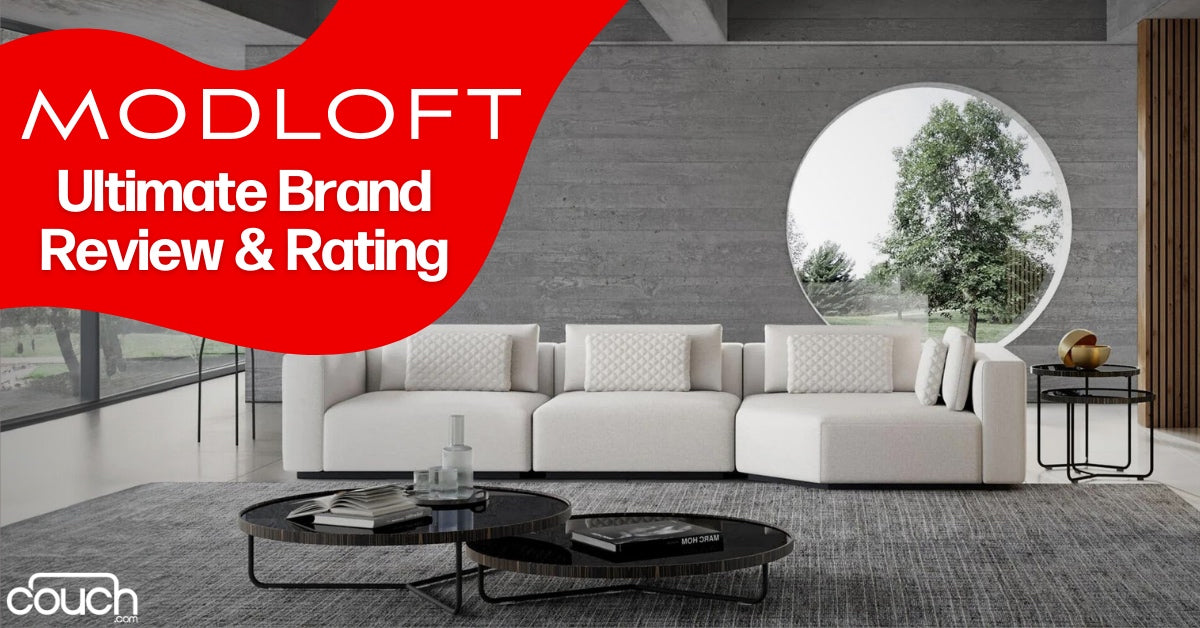 Modern living room with a sleek white sofa, round window showing trees, two circular coffee tables, and a minimalist decor. Text overlay reads "MODLOFT Ultimate Brand Review & Rating" with a red background.