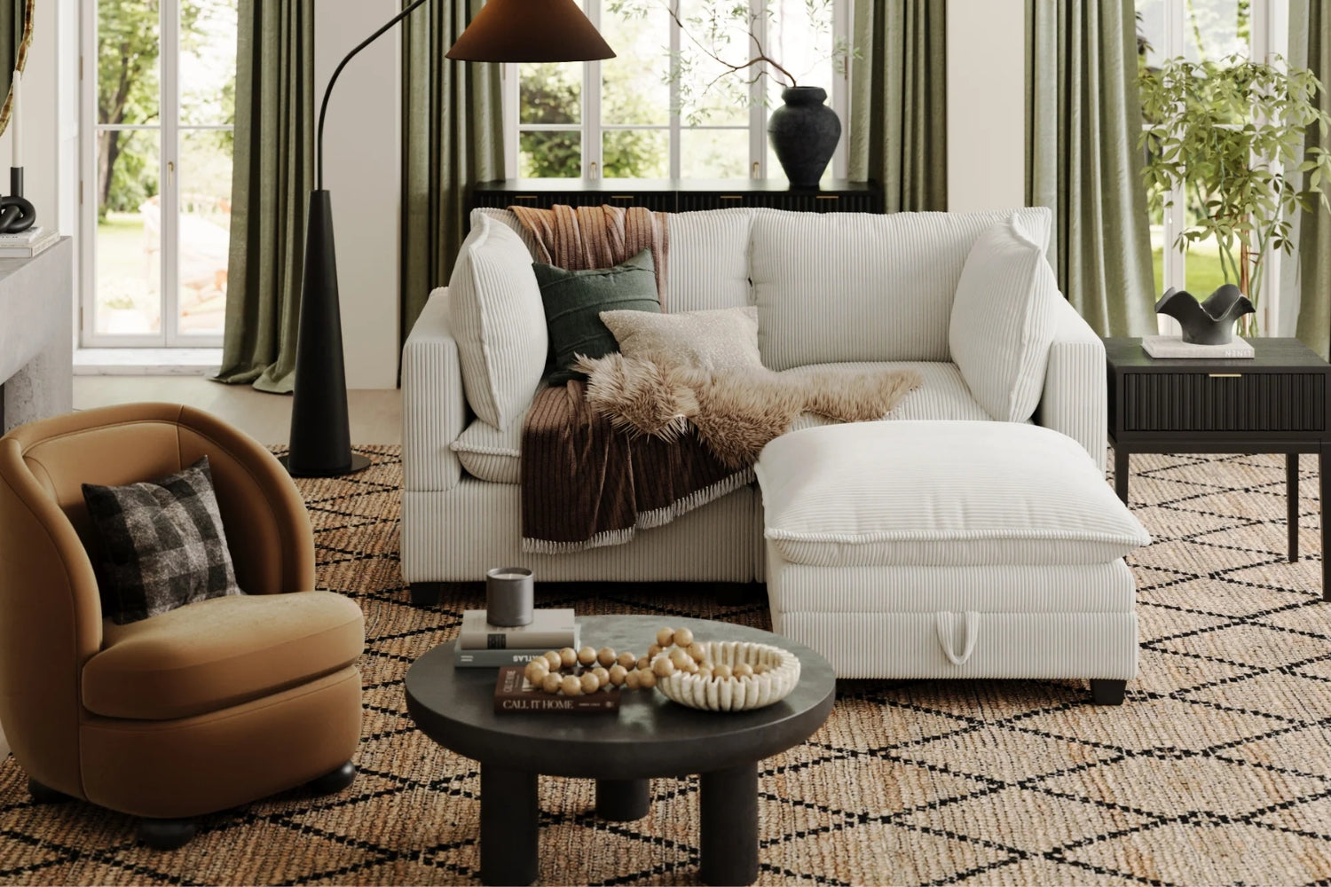 A cozy living room features a white sofa with pillows and a throw, a round tan chair, a black round coffee table with decor, and a textured rug. Green curtains frame large windows, and plants add a fresh touch to the space.