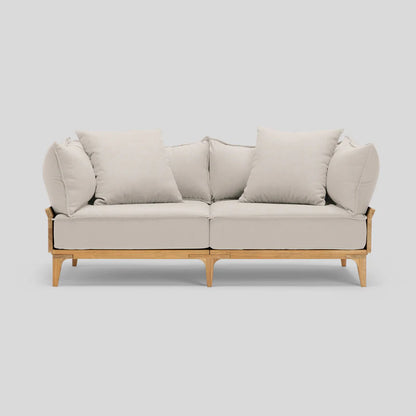 The Bluff Loveseat is a beige, two-seater sofa featuring wooden legs and comes with four matching cushions set against a light gray background.