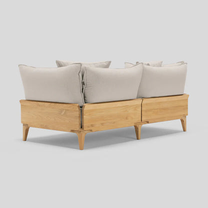 The Bluff Loveseat is a sectional sofa with a wooden frame, featuring light beige cushions and a minimalist design, showcased from the back against a light gray background.