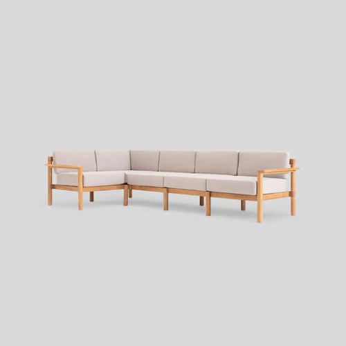 A modern, L-shaped sectional sofa with light beige cushions and a wooden frame, set against a plain light gray background.