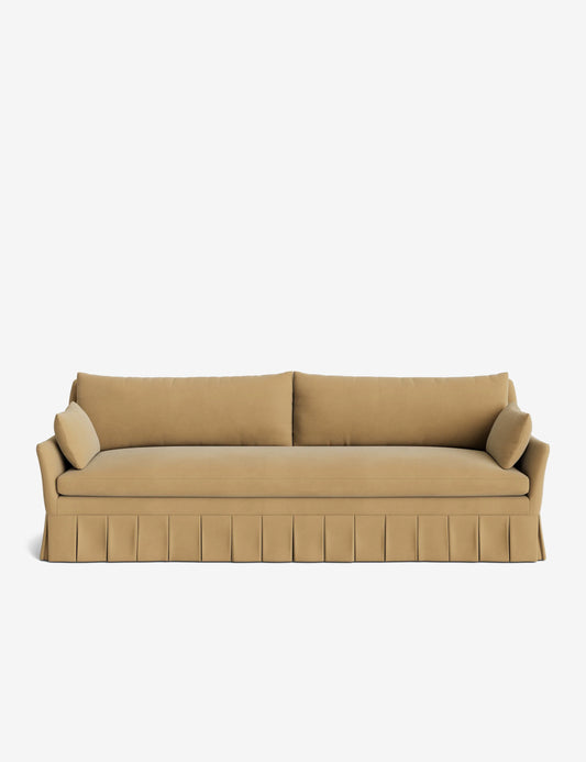 The Portola Pleated Sofa, featuring a beige design with a pleated skirt, comes complete with two long cushions and two cylindrical bolster pillows on each side, all set against a white background.