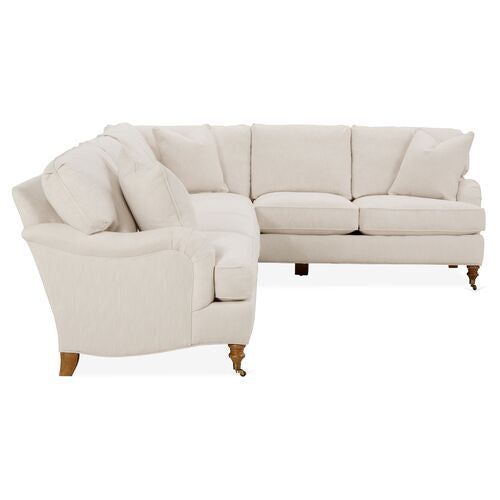 The Brooke 6-Piece Left-Facing Sectional is a white, L-shaped sofa with wooden legs and cushioned seats and backs. It features soft, plush cushions and a classic design, making it perfect for creating a cozy atmosphere in your living room.