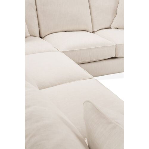 Close-up of the Brooke 6-Piece Left-Facing Sectional in a cream color, featuring plush cushions and a soft fabric texture, with a focus on the corner where two sections connect. The image showcases the smooth and inviting surface, emphasizing the sectional's modern design.