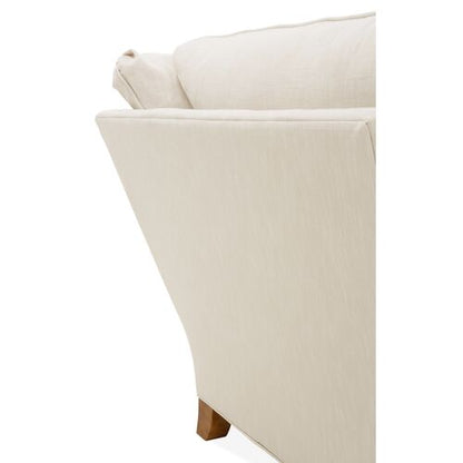 Close-up of the Brooke 6-Piece Left-Facing Sectional's corner, showcasing a sleek, angled backrest and a wooden leg. Its smooth, light-colored upholstery enhances the minimalist design.