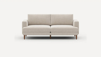 Introducing the Ember Mid-Century Modern 75" Sofa— a contemporary light beige piece showcasing clean lines and a minimalist design. This sofa features two seat cushions and two back cushions, complemented by low armrests and wooden legs, all set against a plain white background.