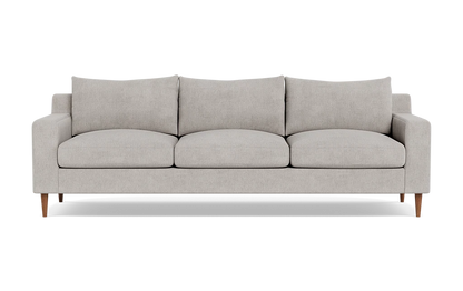 The Sloan Custom 3-Seat 95" Sofa features a modern design with a light gray finish, encompassing three seat cushions and three back cushions. Its clean, simple lines and wooden legs contribute to its minimalist and stylish look. The sofa is presented against a plain black background.