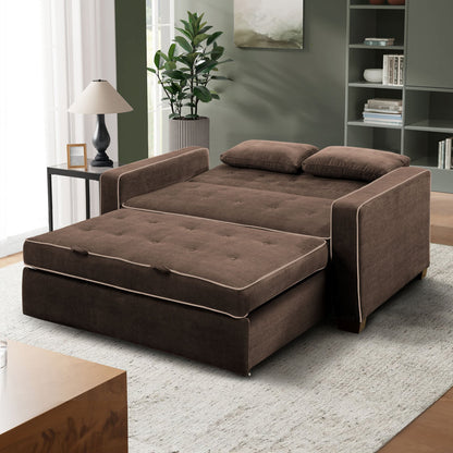 A Serta Monroe Full Size Convertible Sofa in brown is unfolded in a bright living room. It features two cushions, complemented by a small wooden side table with a lamp, a potted plant, and shelves in the background. The decor boasts modern elements with neutral tones.