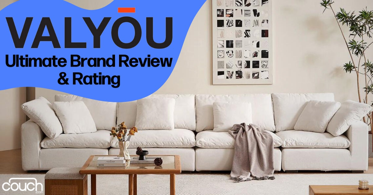 A cozy living room features a large white sectional sofa with a light gray throw draped over it. A wooden coffee table with flowers and a magazine is in front. The wall displays monochrome art. Text reads "Valy≈çu: Ultimate Brand Review & Rating.