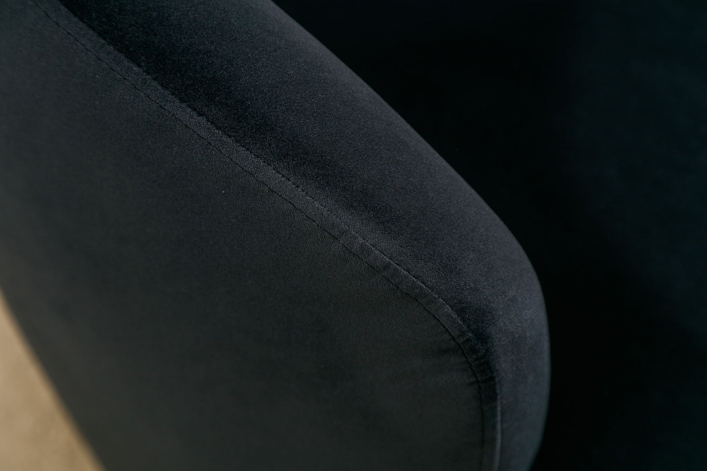 Close-up of the upholstered armrest on the Velvet Fabric Swivel Accent Armchair Barrel Chair, highlighting its smooth velvet texture, detailed seam, and powder-coated metal ring against a neutral background.