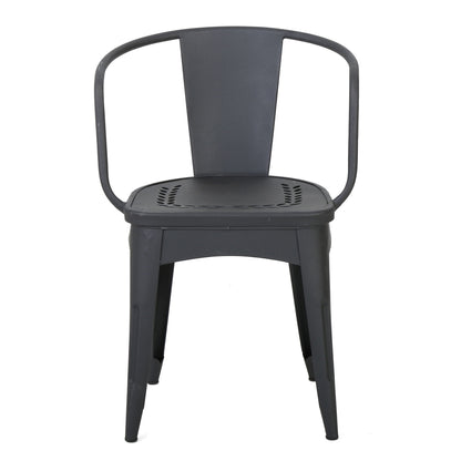 The Ambrosia 3 Piece Bistro Set features black metal chairs with curved backrests, solid seats adorned with leaf motifs cutouts, and four angled legs for a simple, industrial look.