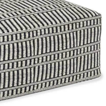Close-up of the Safford Square Woven Outdoor/Indoor Pouf in black and white, featuring a geometric pattern with horizontal and vertical lines and stripes.