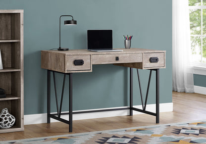 A Computer Desk For Home Office with storage drawers holds a closed laptop, black lamp, and silver cup with pens. To the left is a bookcase; on the floor is a patterned rug; to the right, a window with white curtains.