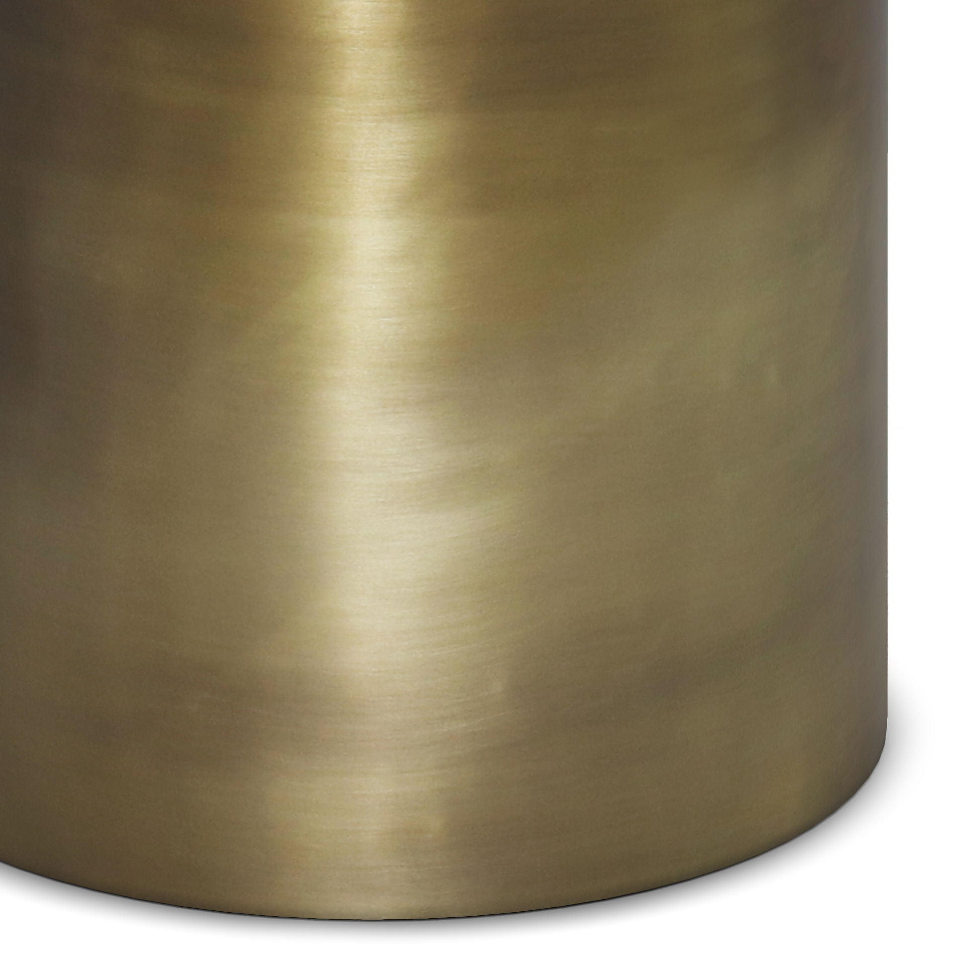 Close-up of the Corbin Handcrafted Metal Side Table featuring a smooth, brushed metallic surface in a warm gold tone. Subtle lighting highlights and shadows accentuate its cylindrical, curved design.
