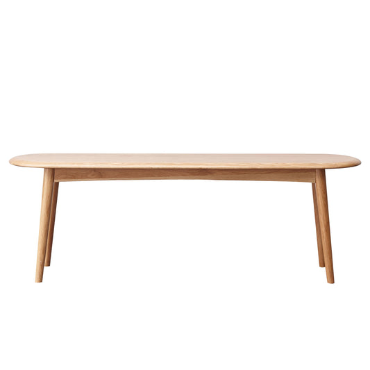 A simple, light wooden Dining Bench, Table Bench For Living Room with rounded edges and four angled legs, photographed against a white background.