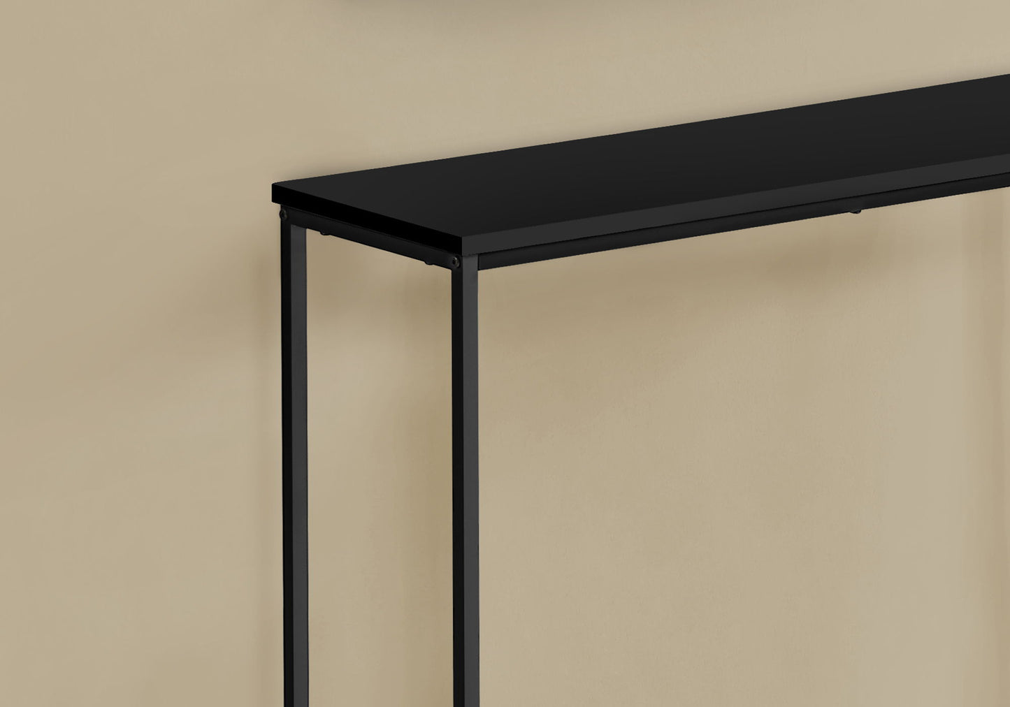 The image highlights the corner and side detail of the Accent Console Table For Entryway, featuring stable support and a contemporary modern design in minimalist black metal, placed against a beige wall.