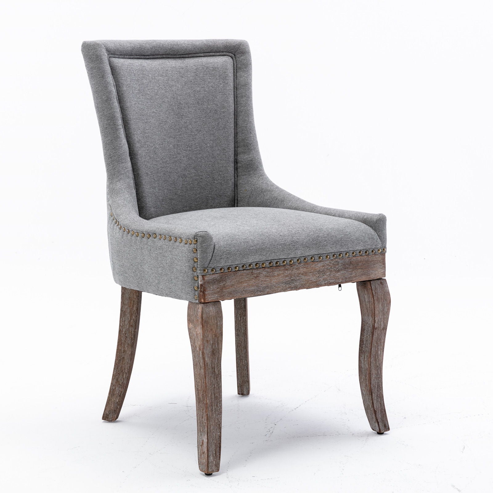 The Ultra Side Dining Chair features thickened gray upholstery, a tall curved backrest, bronze nailhead trim, and neutrally toned solid wood legs with a rustic finish. Sold as a set of 2 and shown against a white background.